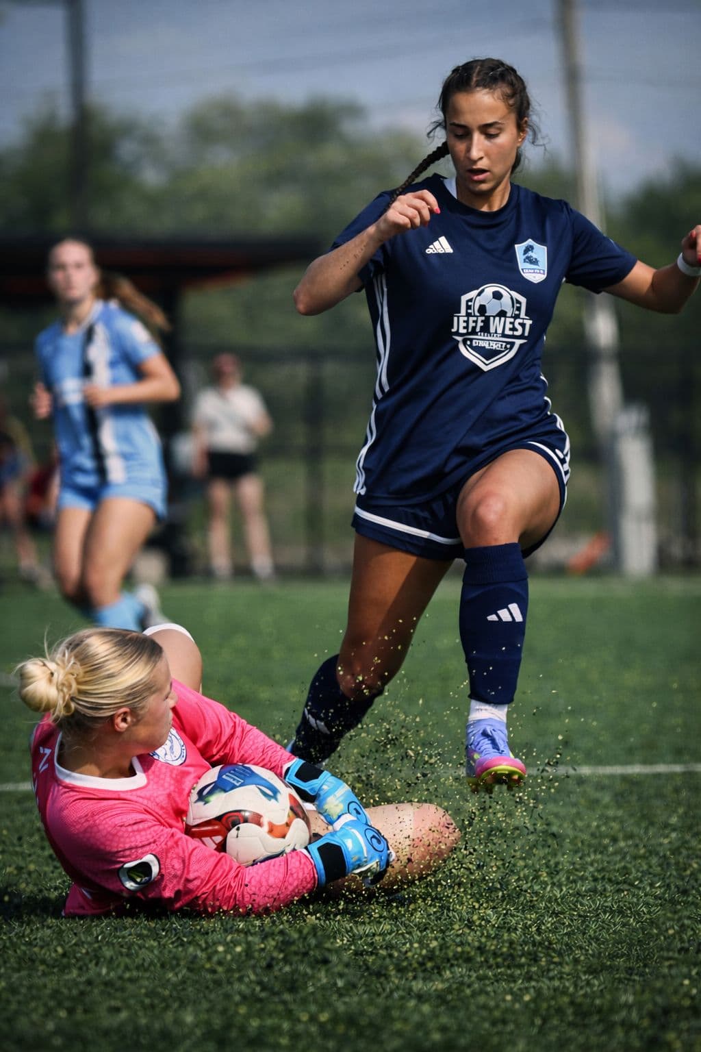 Women's player dribbling past goalkeeper